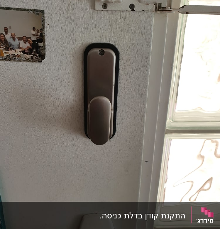 ידית דלת מתכתית ובריח לבן על דלת
